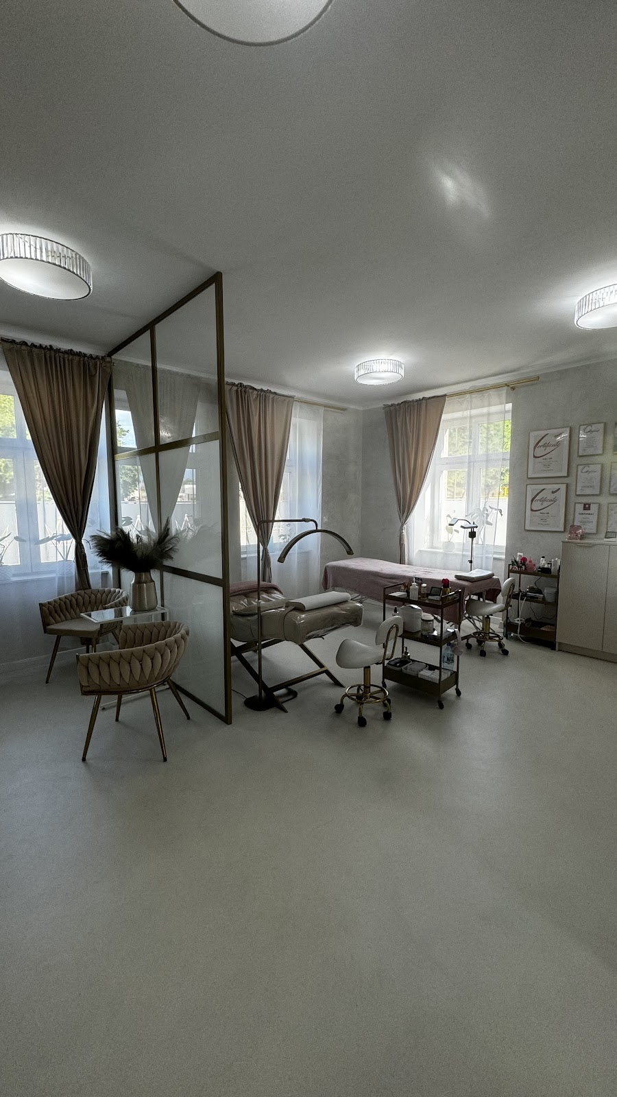 Wnętrze salonu z fotelami zabiegowymi i certyfikatami na ścianie